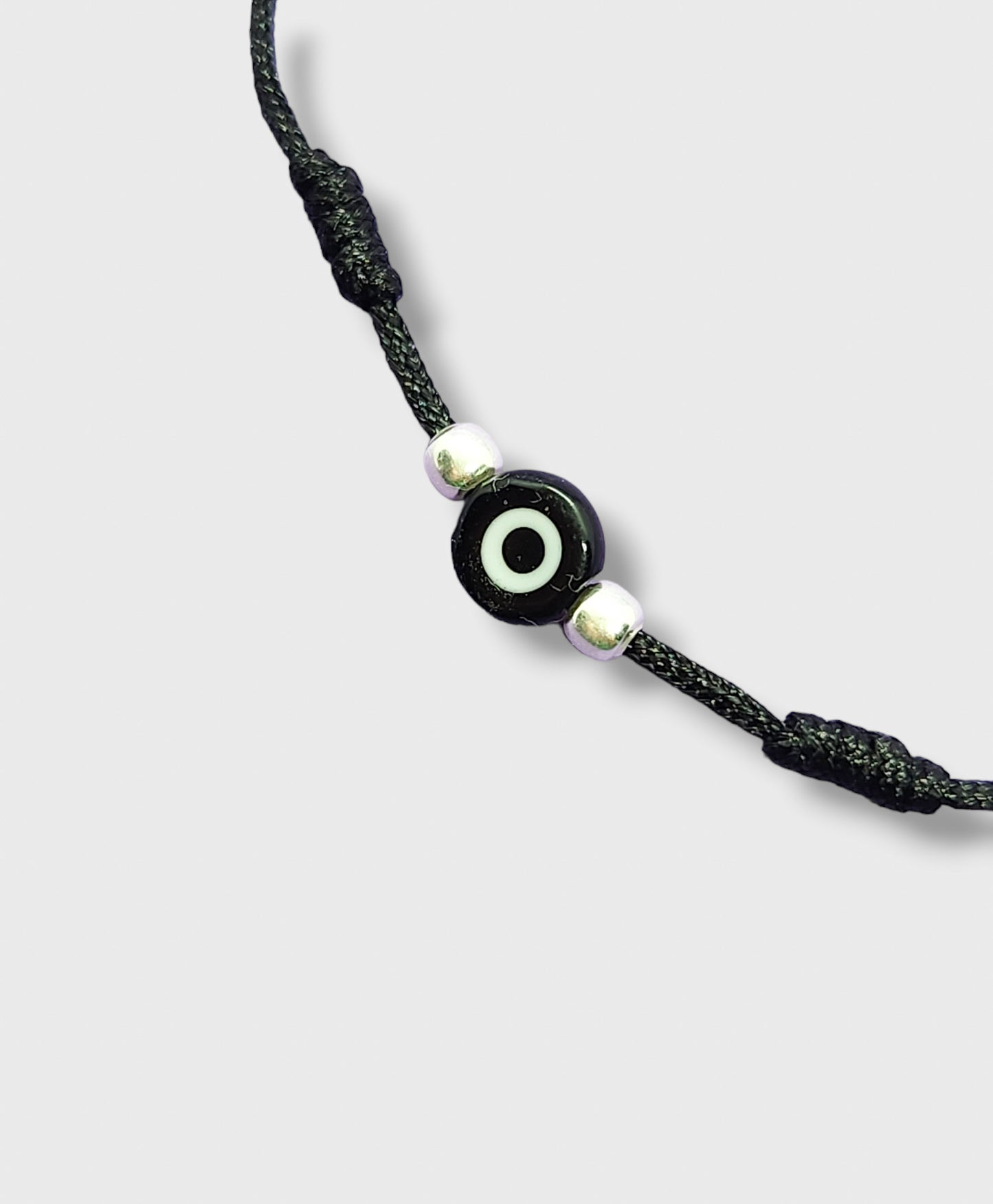 Pulsera de hilo negro con ojo turco y bolitas de plata
