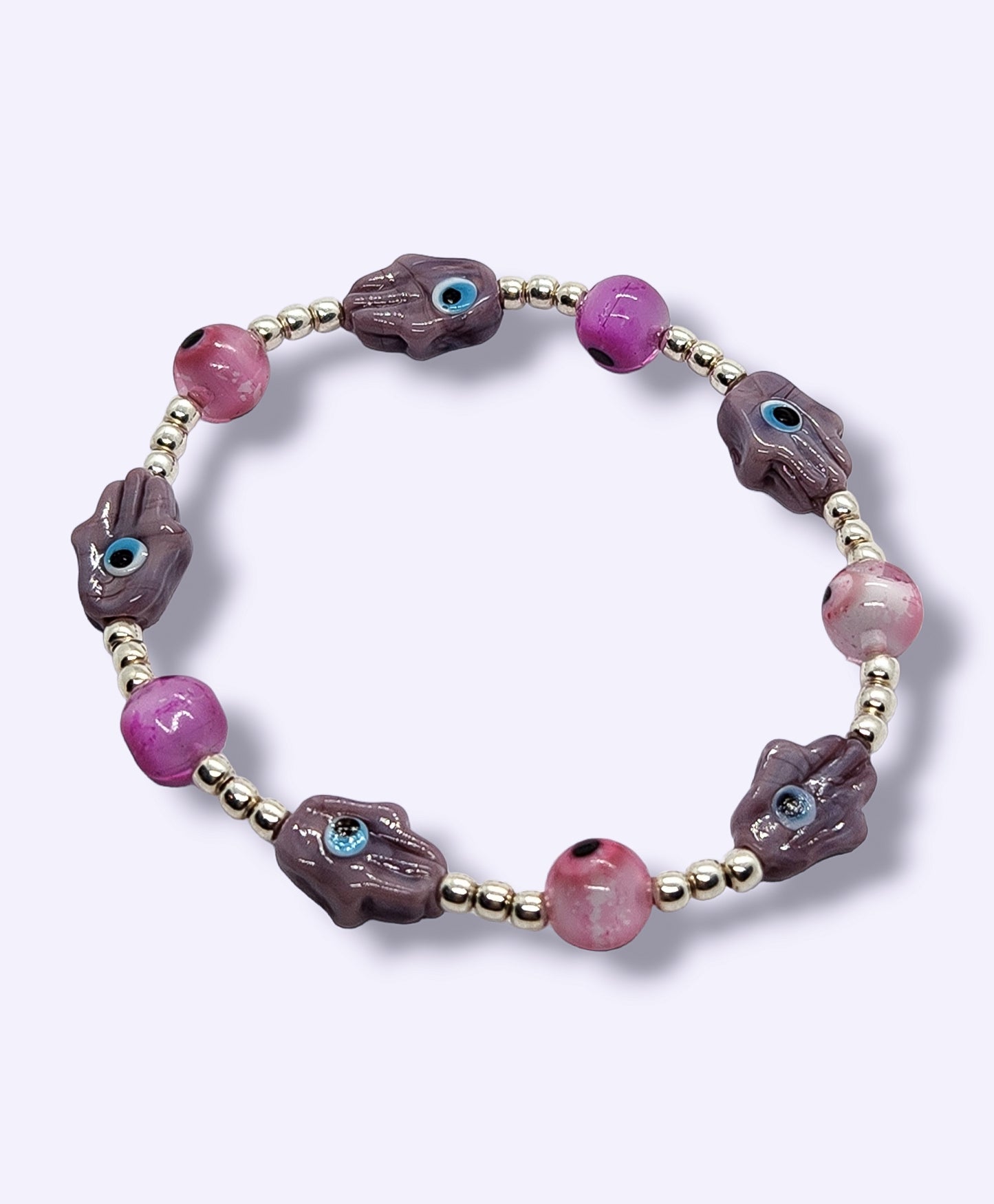 Pulsera de bolitas de plata con ojito turco rosa y mano morada