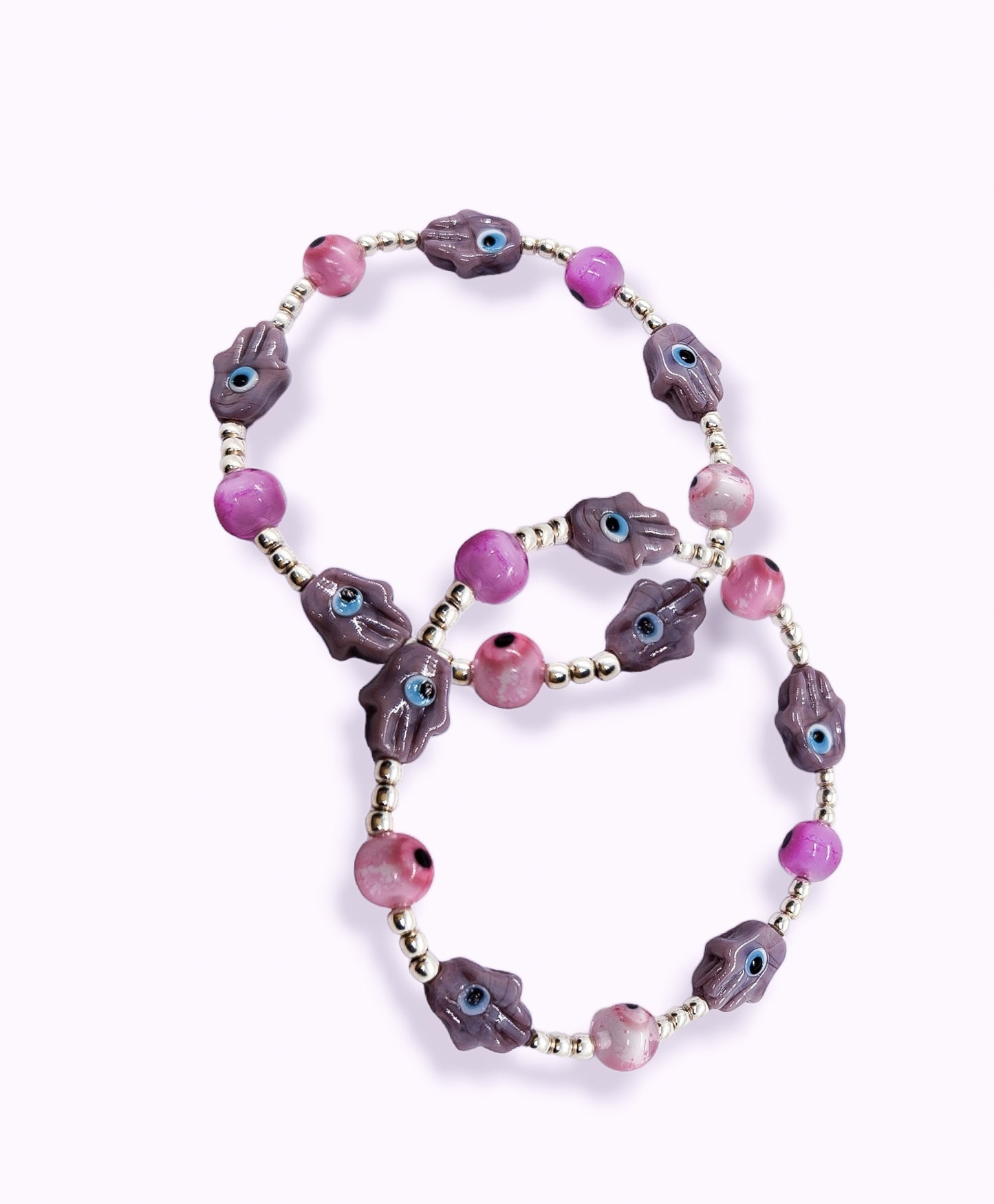 Pulsera de bolitas de plata con ojito turco rosa y mano morada
