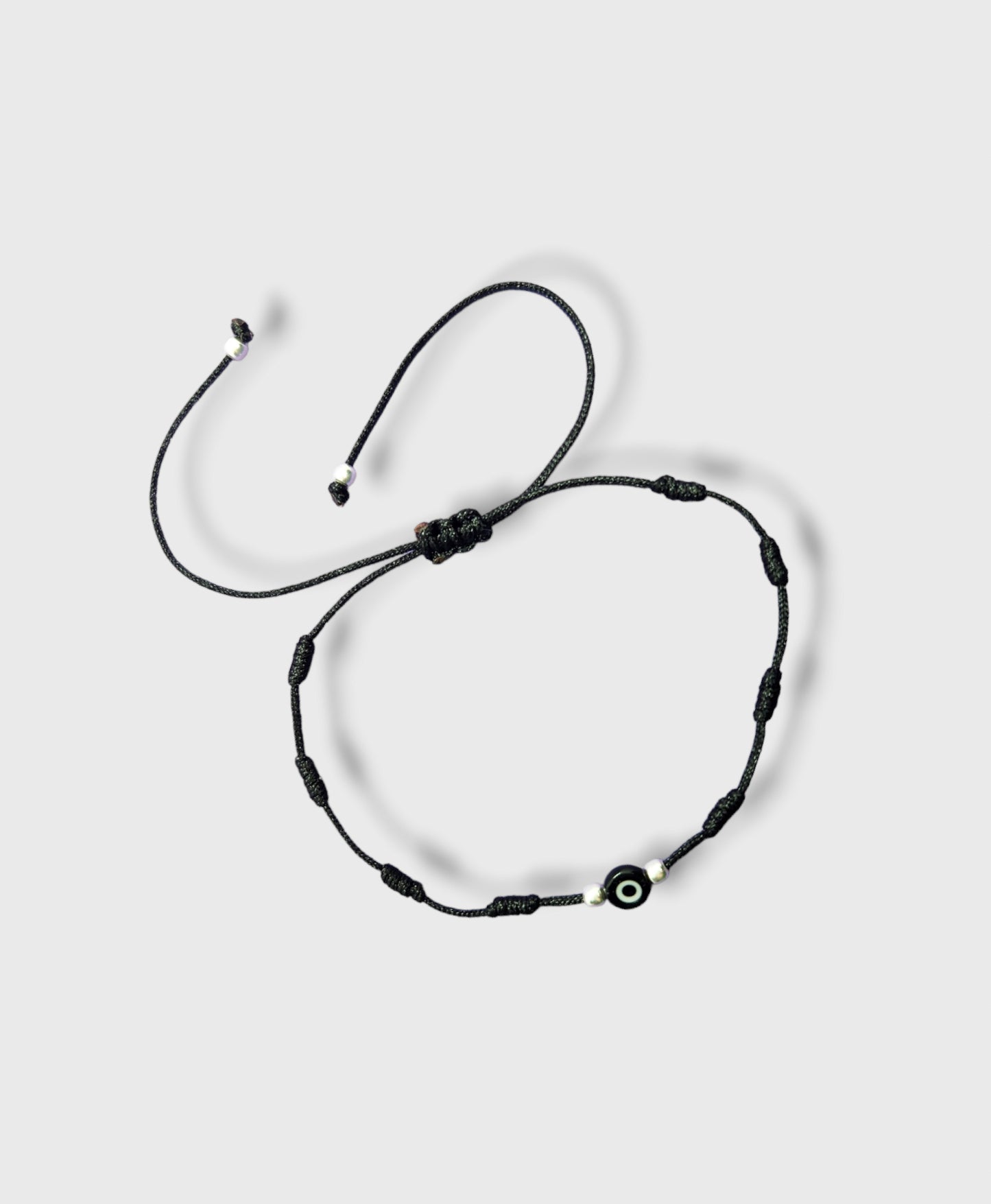 Pulsera de hilo negro con ojo turco y bolitas de plata